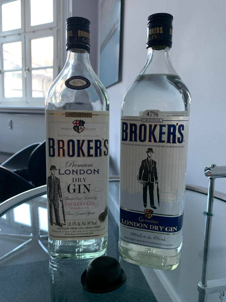 Two bottles of Brokers Premium Gin on reflective table with vintage branding in bright room Wallpaper