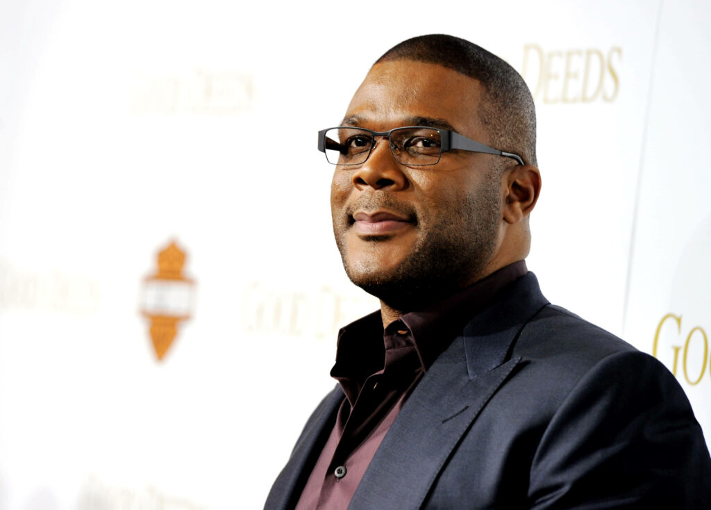 Tyler Perry in stylish suit confident pose clean background Hollywood filmmaker wallpaper
