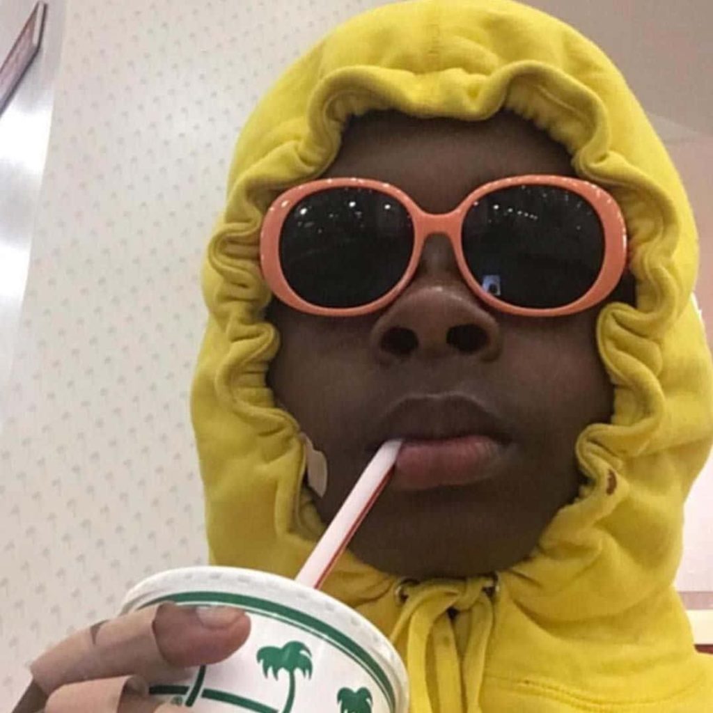 Tyler the Creator selfie wearing yellow hoodie orange sunglasses holding In-N-Out cup wallpaper