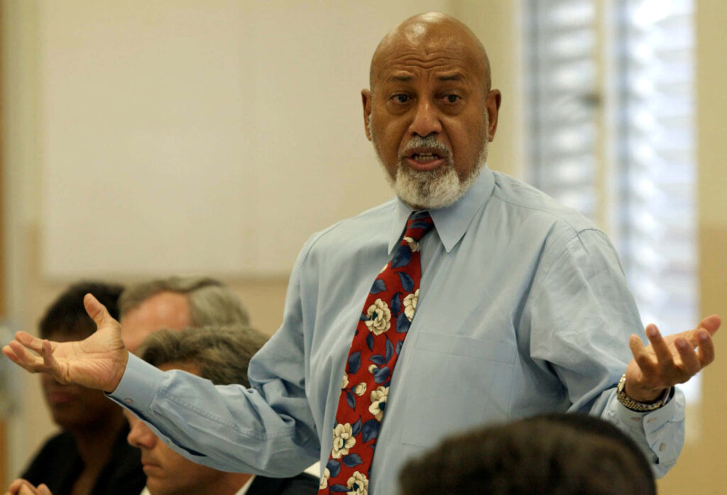 U.S. Congressman Alcee Hastings passionately speaking in formal setting with wallpaper background