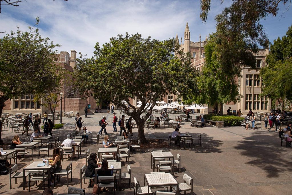 Sunlit UCLA Kerckhoff Coffee House courtyard with students studying under collegiate Gothic architecture Wallpaper