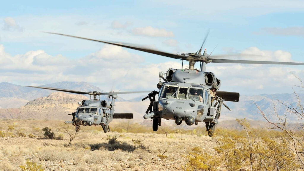US Black Hawk helicopter flying over rugged desert landscape showcasing military aviation power Wallpaper