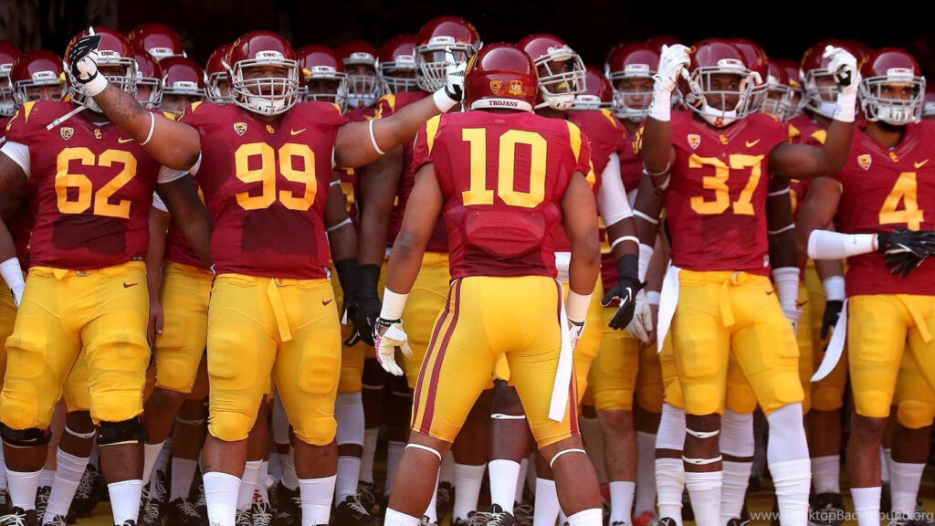 USC Trojans Football Players Wallpaper: Iconic Team Spirit Background