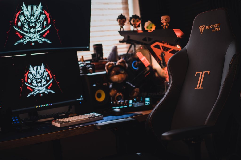 Dark gamer room wallpaper with Secretlab chair dual monitors samurai and Dragon Ball Z Funko Pops