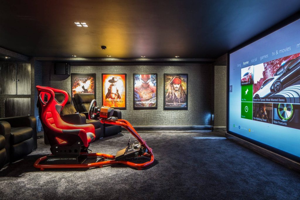 Red racing simulator rig with Xbox 360 dashboard on projector screen in cinematic gaming room Wallpaper