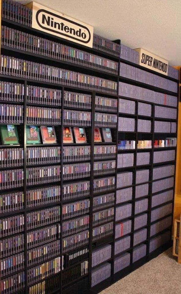 Massive organized NES and Super Nintendo cartridge collection on shelves with wood signage Wallpaper