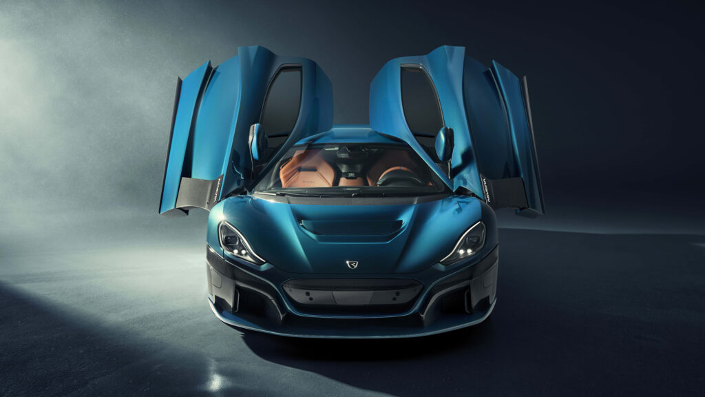 Ultra-modern blue high-performance sports car with butterfly doors open on open road 4K wallpaper