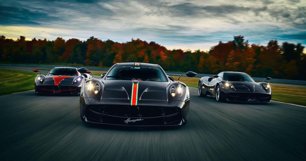 Three high performance supercars racing on autumn track under dramatic colorful sky in 4K Wallpaper