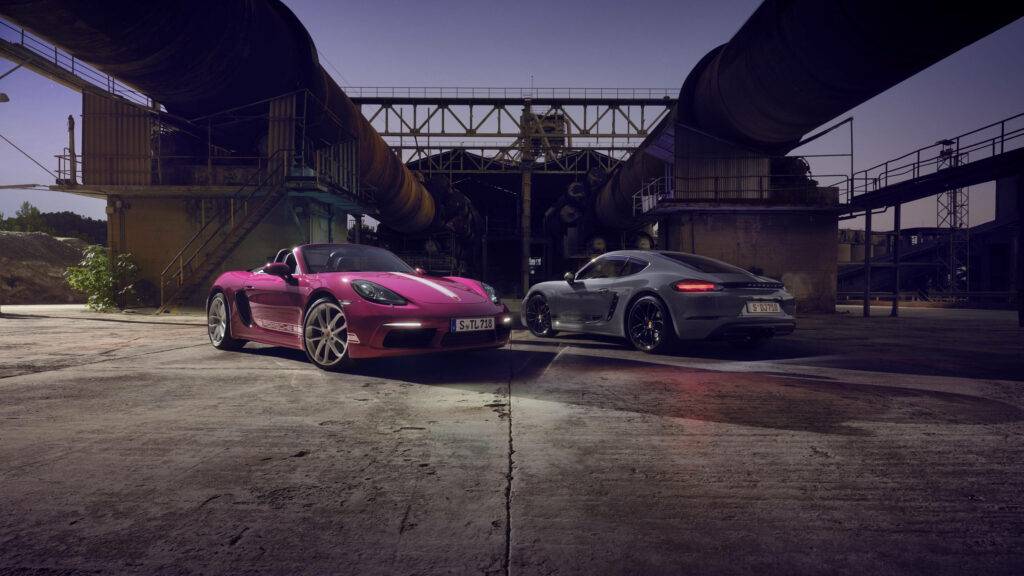Two Porsche sports cars side by side in industrial setting ultra wide dynamic high quality wallpaper
