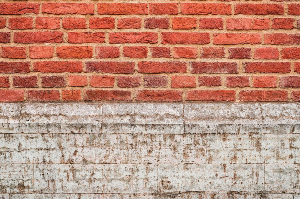Red brick wall in classic bond pattern on weathered off-white sandstone base rustic texture background Wallpaper
