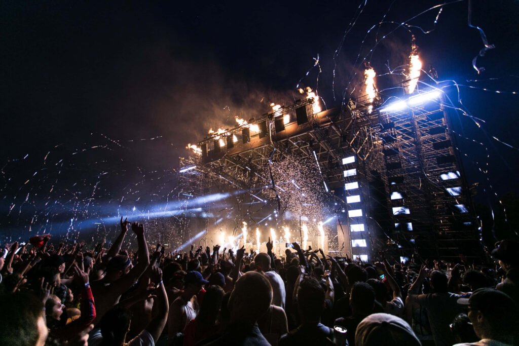 Dynamic Music Festival Unleashing Unstoppable Energy with Vibrant Crowd and Ribbon Confetti Spectacle Wallpaper