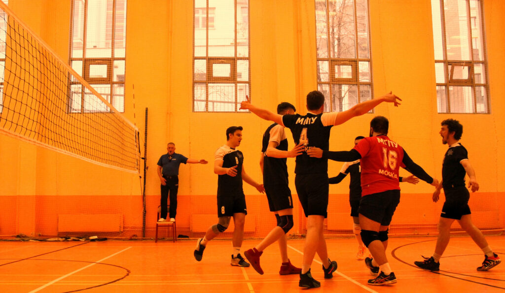 The Unified Uproar: Volleyball Team Converges for a Tactical Huddle in the Vibrant Monochromatic Arena Wallpaper