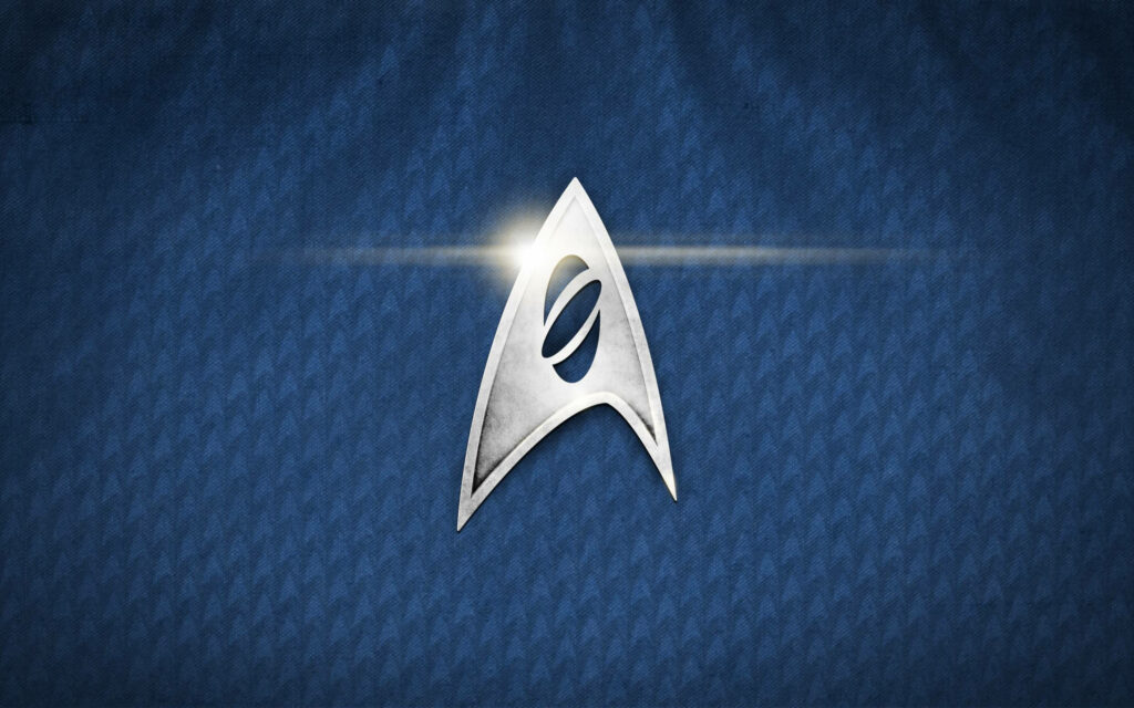 Galactic Harmony: The Legendary Star Trek Emblem Blending Worlds and eras Wallpaper