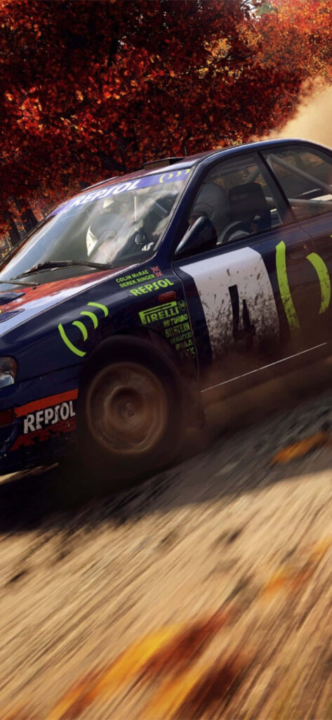 Dirt Rally car power-sliding through autumn forest with motion blur and sponsorship logos Wallpaper