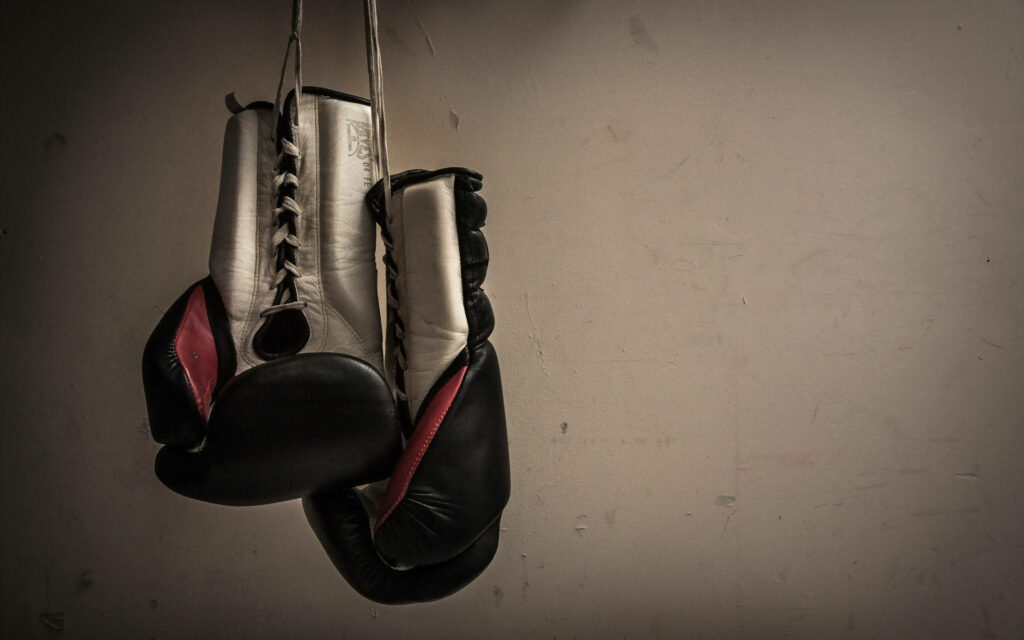 The Power of Determination: A Boxer Punches It Out in the Ring Wallpaper