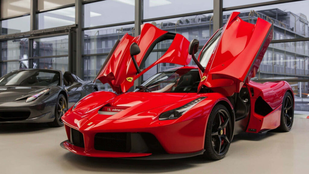 Iconic Power Unleashed: Enthralling Scene of a Red Ferrari LaFerrari Roaring through Serene Greenery Wallpaper