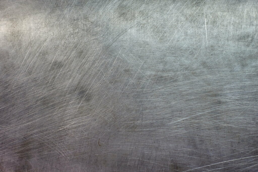 Industrial grunge brushed steel metal texture with crisscrossing scratches sleek background Wallpaper