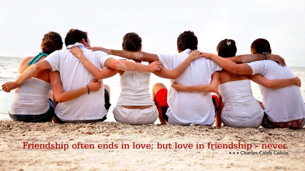 Six friends linked arms on sunny beach with Charles Caleb Colton friendship love quote wallpaper