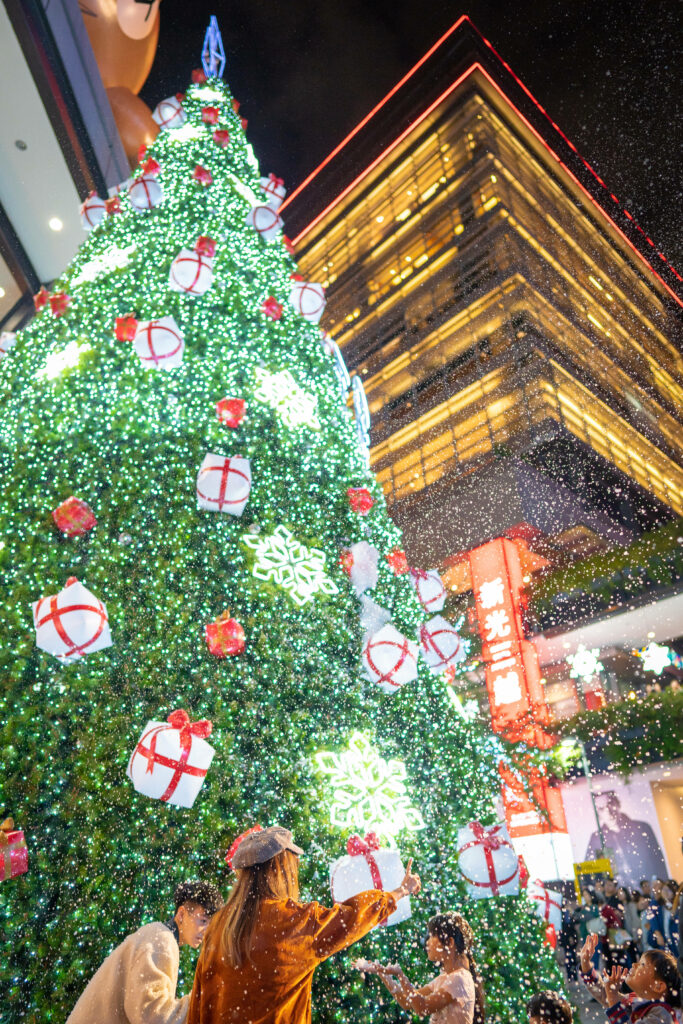 Festive Urban Christmas Tree Wallpaper with Glowing Lights & Snow
