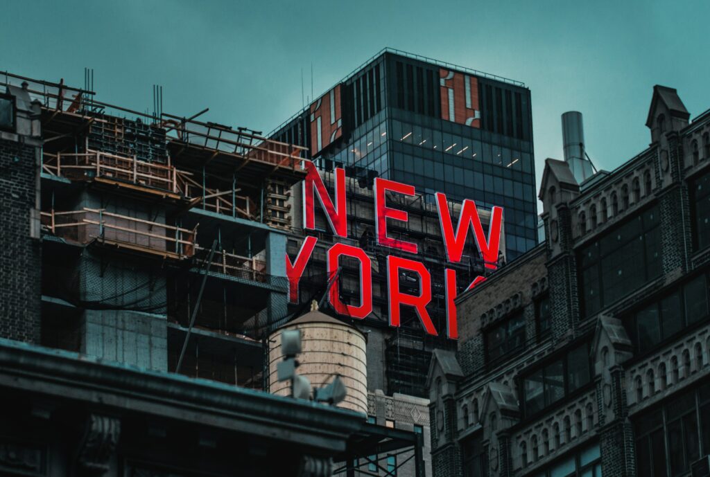 Bold New York Urban Scene Wallpaper: Red Lit Signage & Towering Buildings