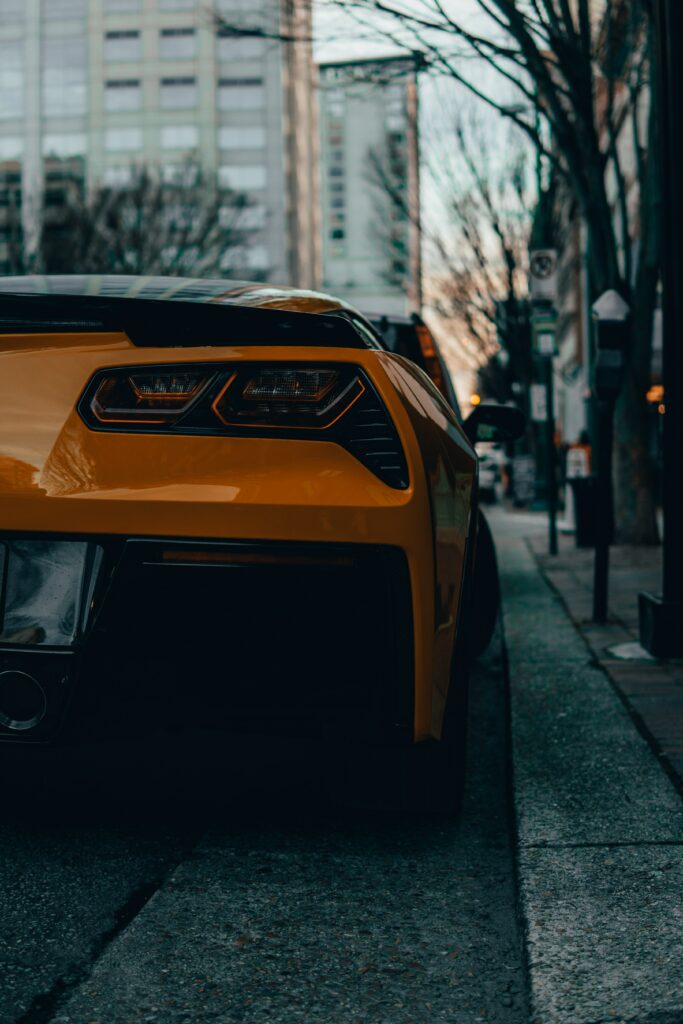 Orange Sleek Car in Urban Setting: Dynamic Night Wallpaper