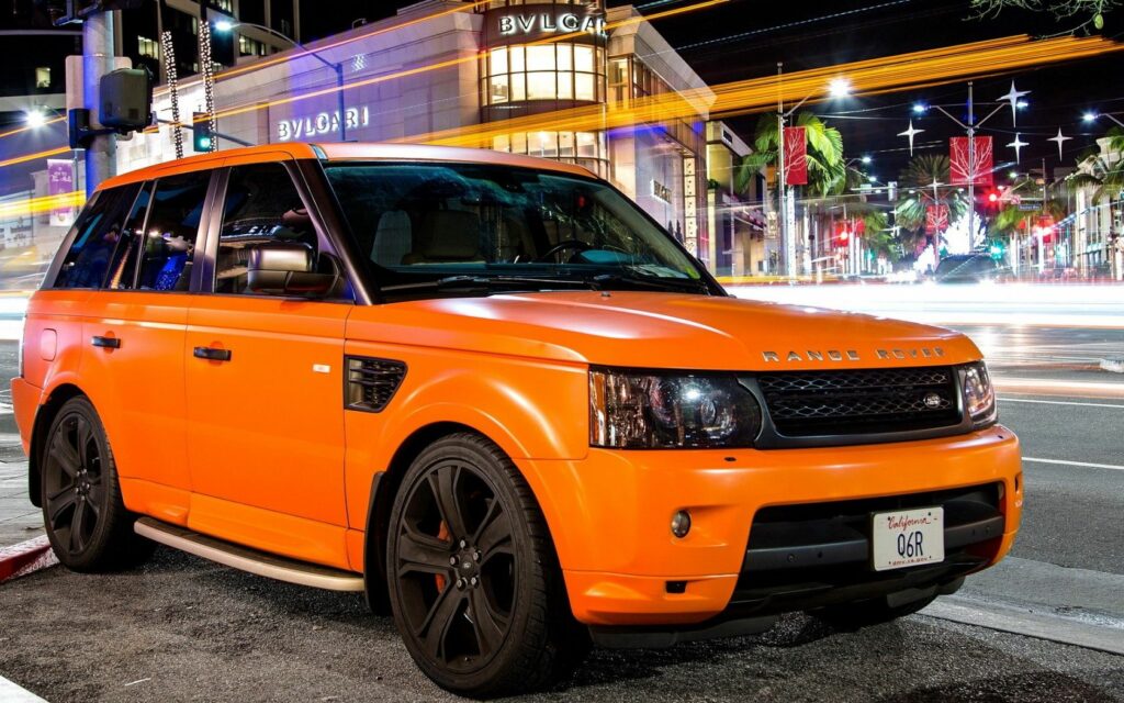 Dynamic Orange Land Rover Wallpaper in Urban Night Scene