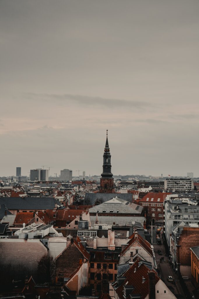 Serene Urban Scene Wallpaper: Tower Over Quaint Red-Tiled Roofs