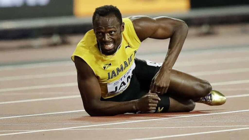 Usain Bolt in Jamaican uniform fallen on track during intense race dynamic emotional wallpaper