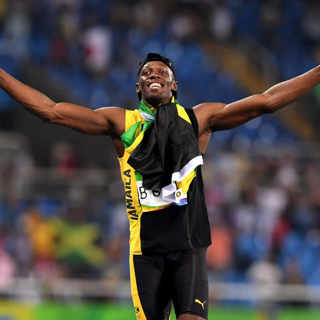 Usain Bolt sprinting and celebrating on track showing energy and Jamaican national pride wallpaper