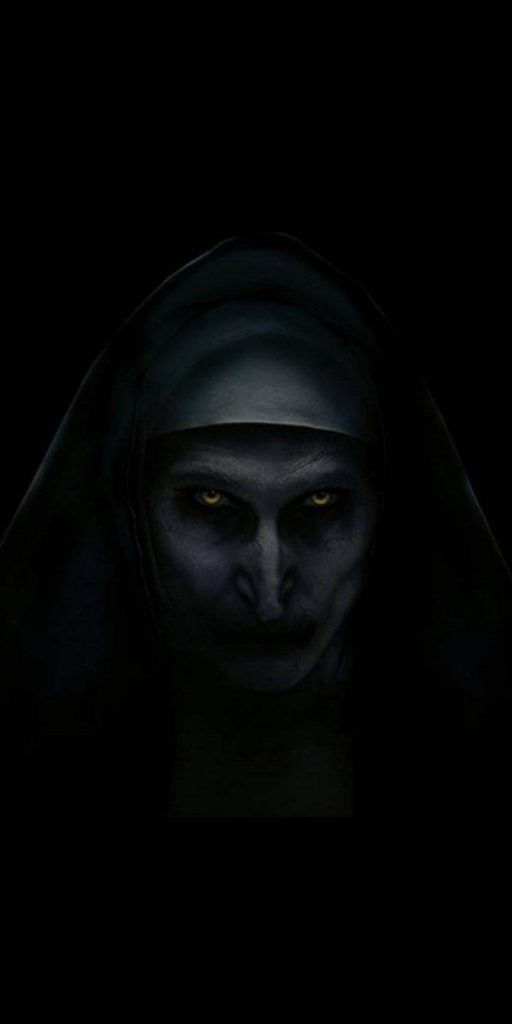 Minimalist wallpaper of Valak demon nun with pale face and yellow eyes on black background