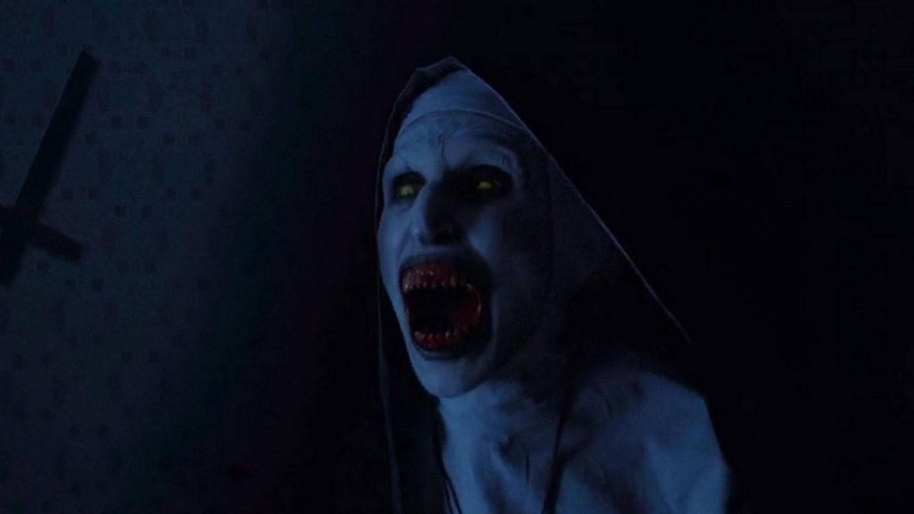 Valak demonic nun from The Conjuring with sharp teeth screaming in dark shadowy horror wallpaper