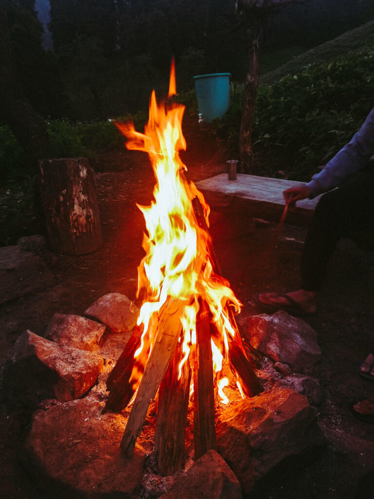 Vibrant 4k campfire wallpaper with crackling flames surrounded by rustic logs and forest stones