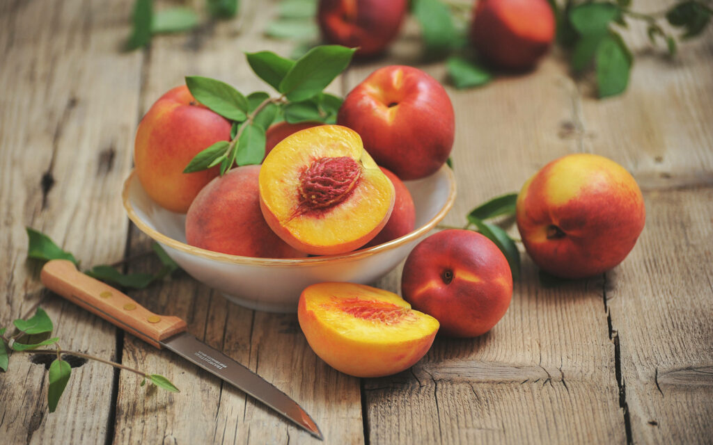 Vibrant 4K Peach and Nectarine Wallpaper on Rustic Wooden Surface