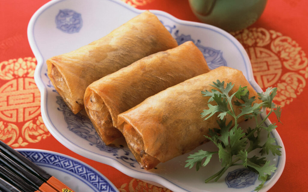 Vibrant 4K Spring Rolls Wallpaper on Red Background with Cilantro