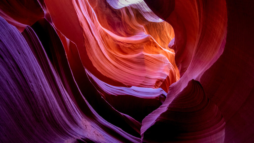 Abstract canyon wallpaper with vibrant orange red purple layered rocks and soft natural light