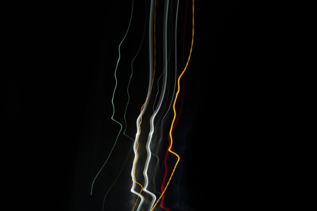 Vibrant Abstract Wallpaper: Streaking Light Trails on Dark Background