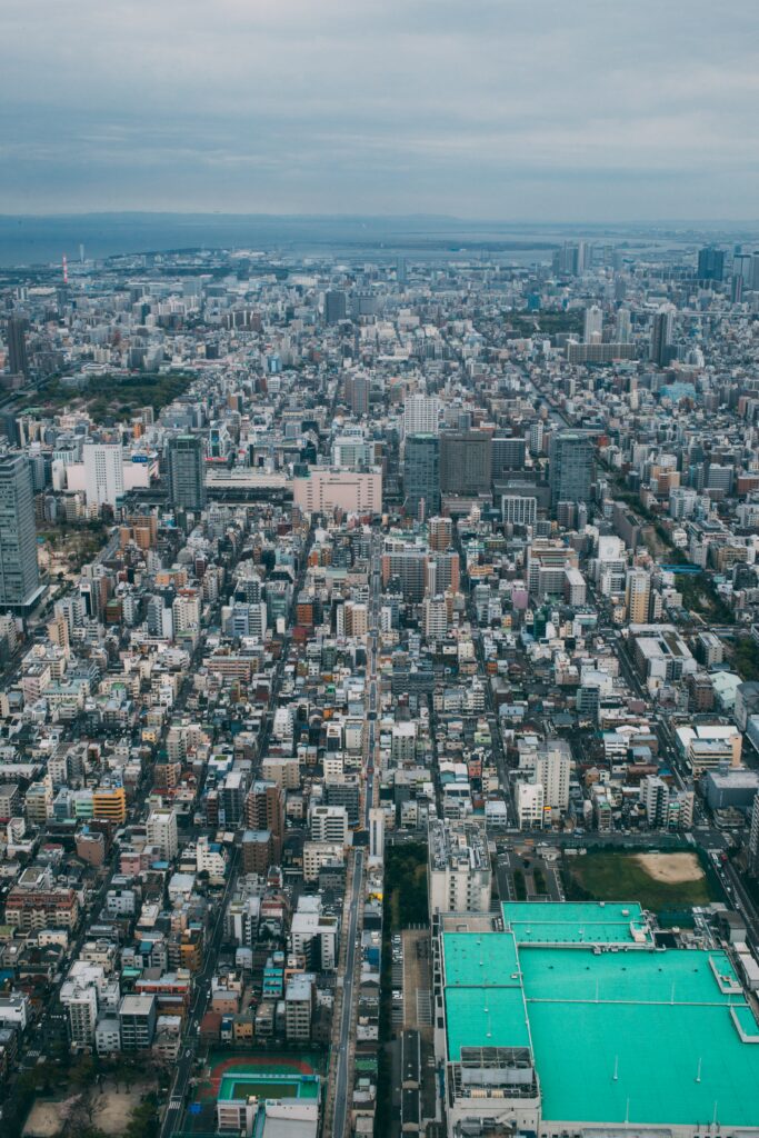 Vibrant Cityscape Wallpaper: Aerial View of Urban Density Under Clouds