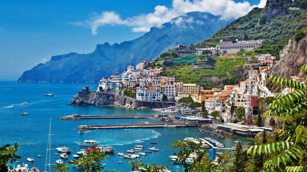 Vibrant Amalfi Coast pier with colorful cliffside buildings and boats docked by blue sea wallpaper