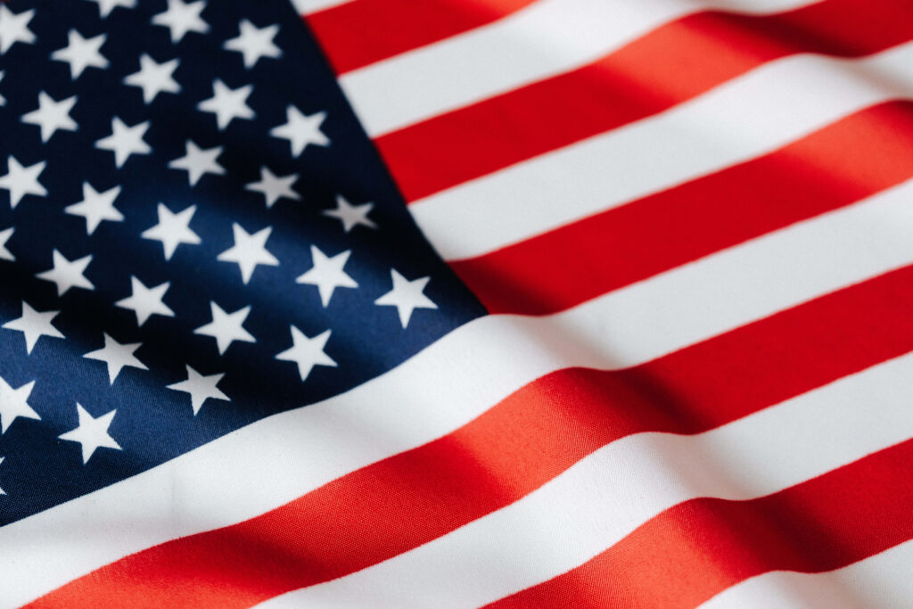 Vibrant American Flag Wallpaper Against a Pristine Sky Background