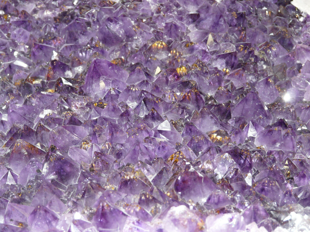 Close-up of vibrant purple amethyst crystal tips with natural geometric patterns wallpaper
