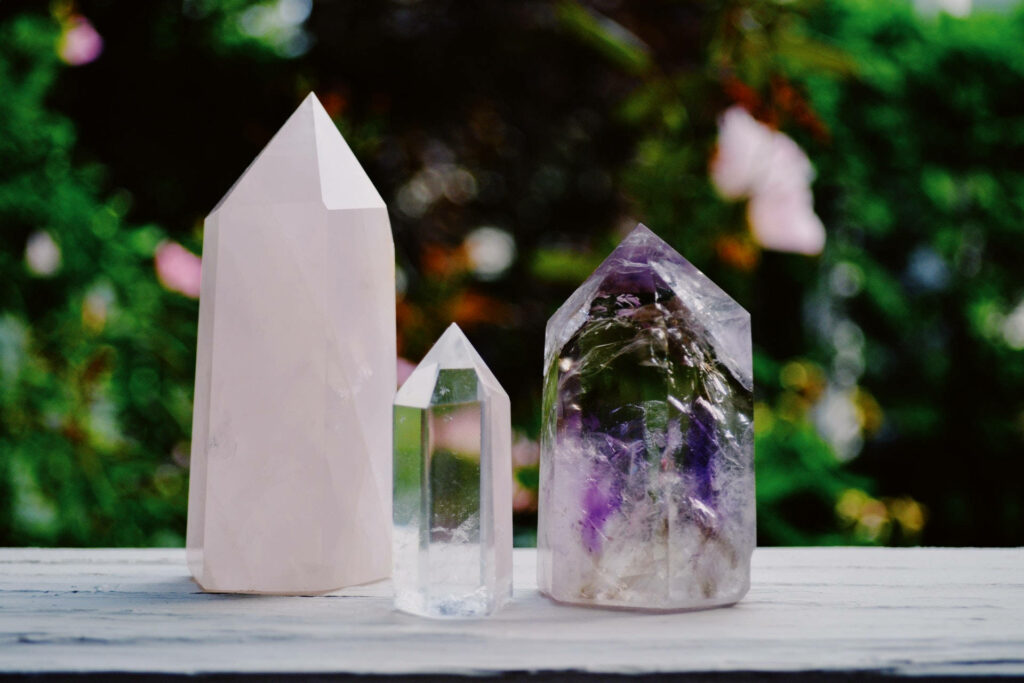 Trio of crystal towers with vibrant purple amethyst single pointed tower on soft background Wallpaper
