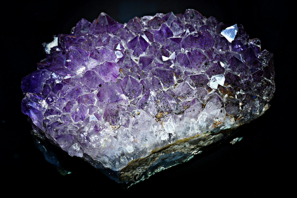 Close-up of vibrant purple amethyst geode crystals with intricate natural textures wallpaper background