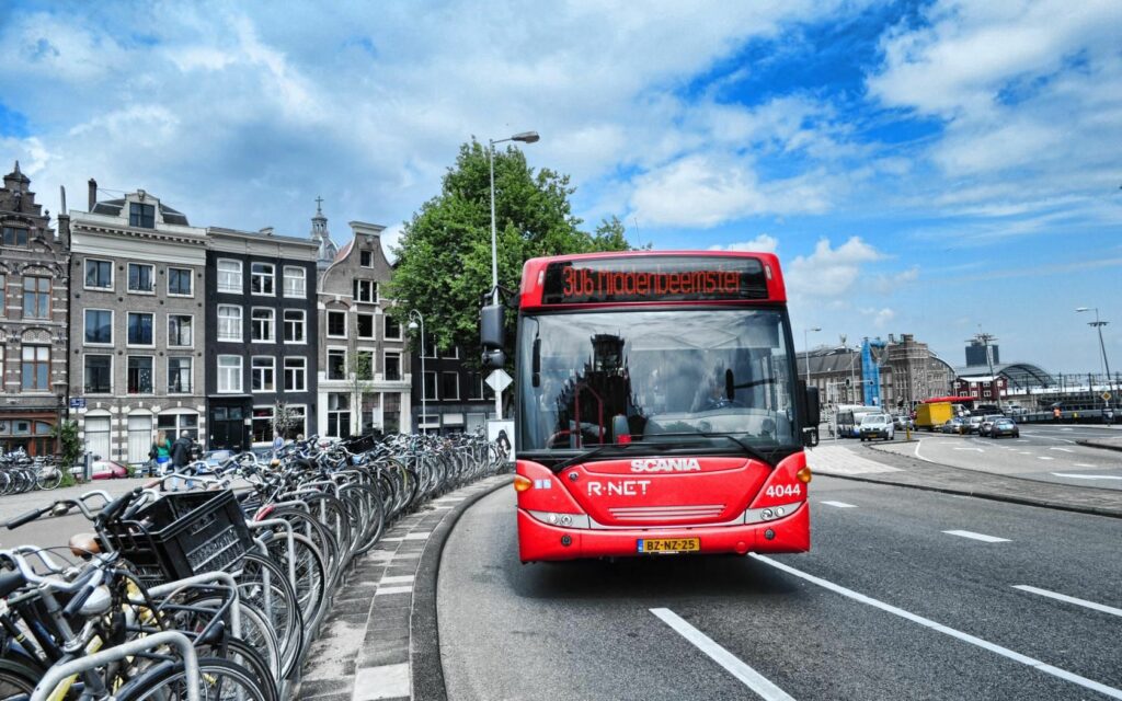 Vibrant Amsterdam Wallpaper: R-NET Bus, Bicycles & Historic Buildings