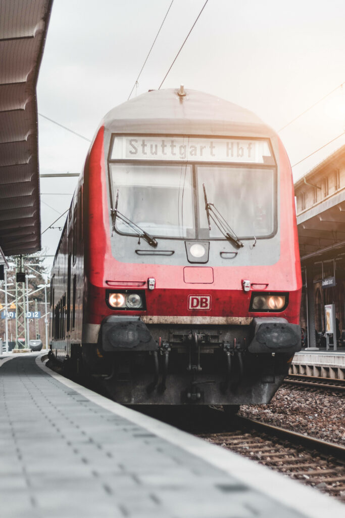 Iconic Scarlet Locomotive Pulls into Vibrant Stuttgart Railway Hub Wallpaper