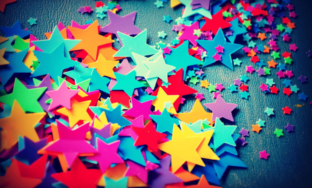 Vibrant Assortment of Plastic Star Confetti Adds Pizzazz to Background Capture Wallpaper