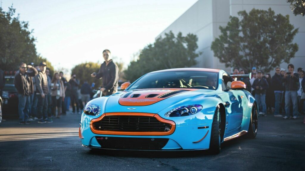 Vibrant Blue & Orange Aston Martin Wallpaper – Automotive Event Scene