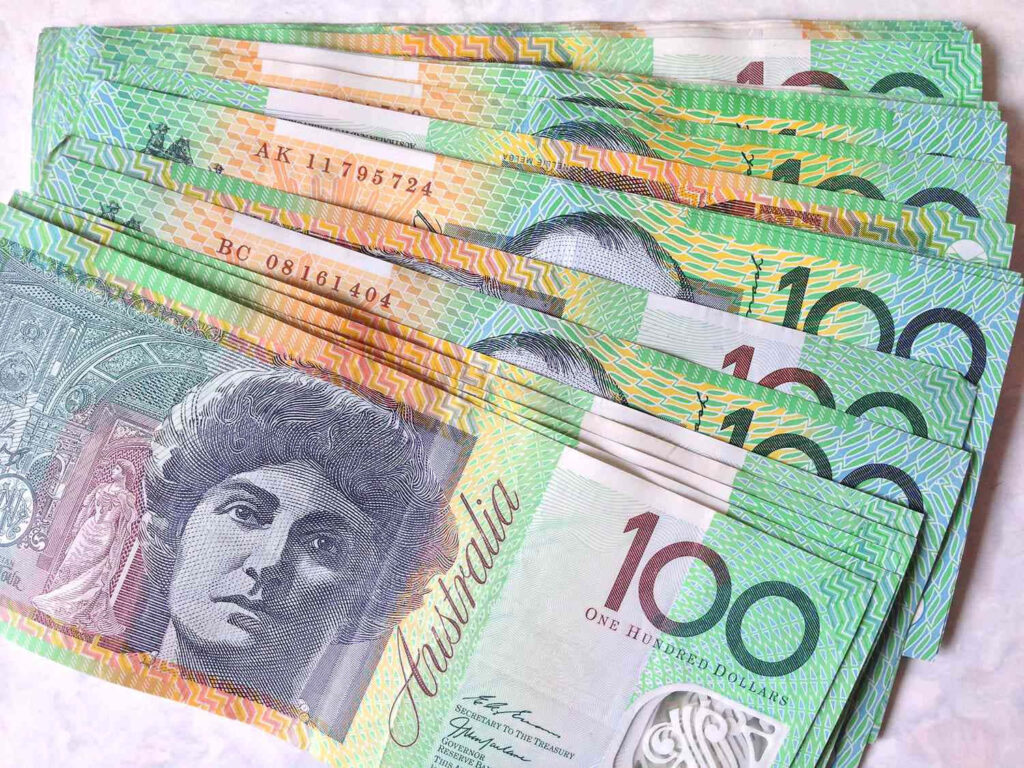 Close-up of stacked Australian 100 dollar banknotes with vibrant colors and detailed designs Wallpaper