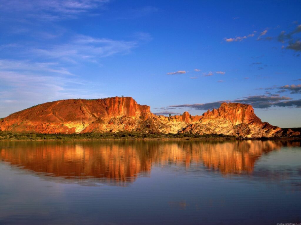 Vibrant Australian coast red rocks cliffs reflected in calm sea under clear blue sky wallpaper