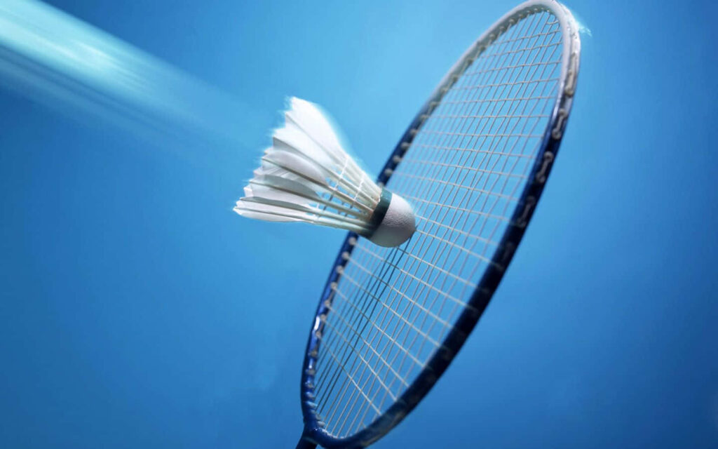 Close-Up of Badminton Shuttlecock Hitting Racket on Blue Background Wallpaper