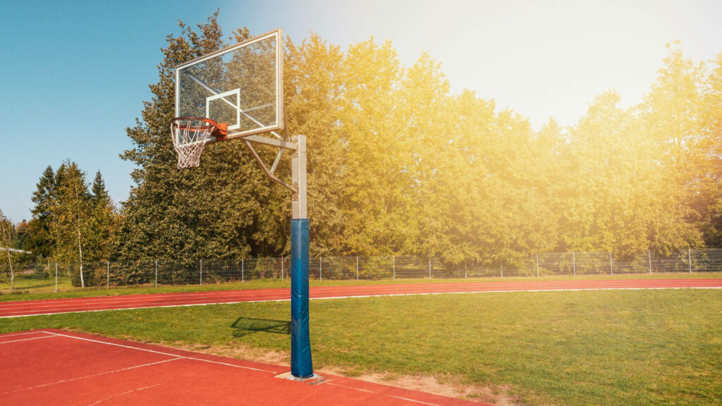 Vibrant College Outdoor Basketball Court Wallpaper in Sunlit Serenity